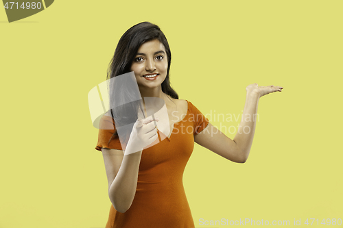 Image of Portrait of beautiful woman isolated on yellow studio background