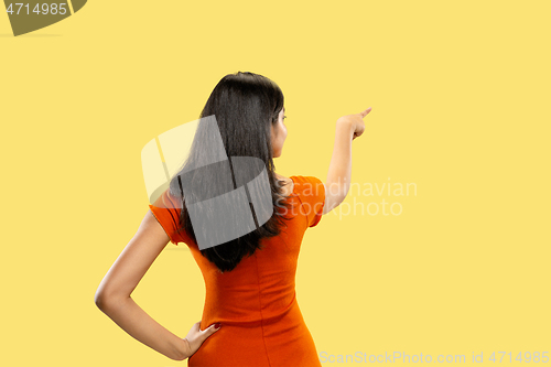 Image of Portrait of beautiful woman isolated on yellow studio background