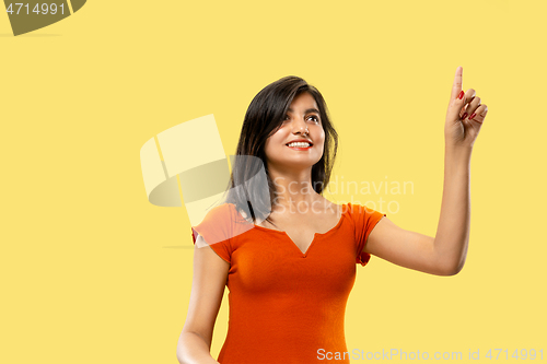 Image of Portrait of beautiful woman isolated on yellow studio background