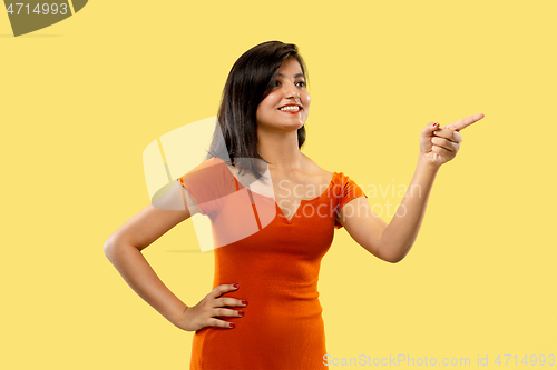 Image of Portrait of beautiful woman isolated on yellow studio background