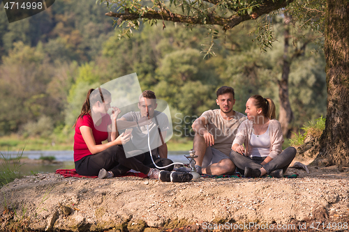 Image of friends smoking hookah on the river bank