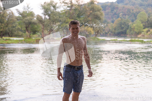 Image of man with a bare torso splashing water