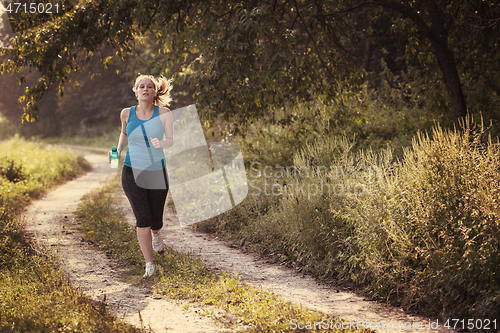 Image of woman jogging along a country road