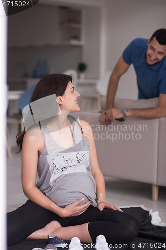 Image of pregnant couple checking a list of things for their unborn baby