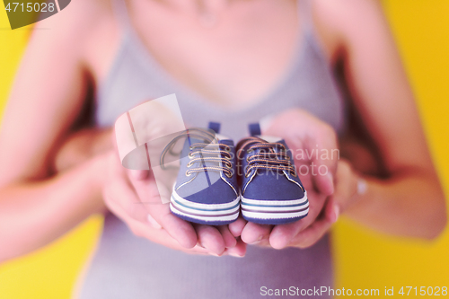 Image of couple holding newborn baby shoes