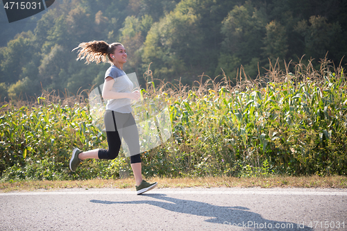Image of woman jogging along a country road