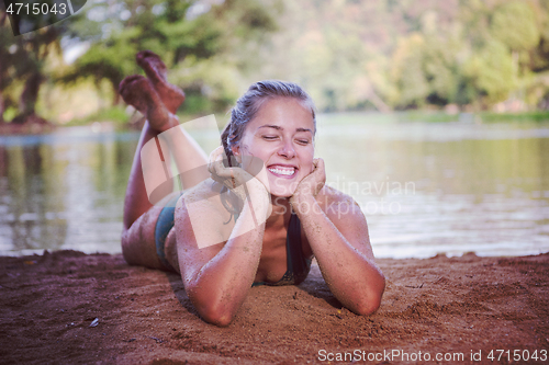 Image of girl in a green bikini relaxing on the riverbank