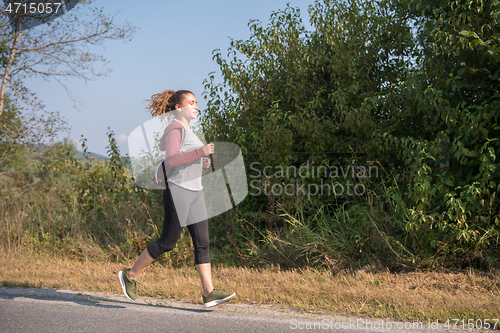 Image of woman jogging along a country road