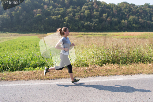 Image of woman jogging along a country road