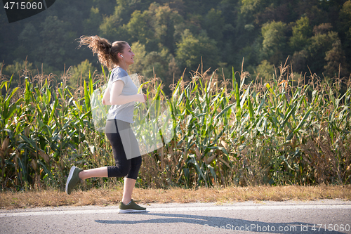 Image of woman jogging along a country road