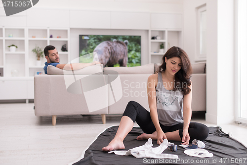 Image of pregnant couple checking a list of things for their unborn baby