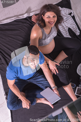 Image of top view of couple checking a list of things for their unborn ba