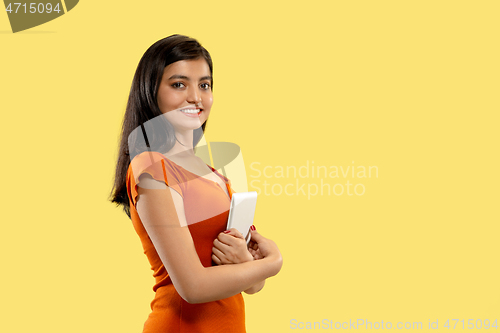 Image of Portrait of beautiful woman isolated on yellow studio background