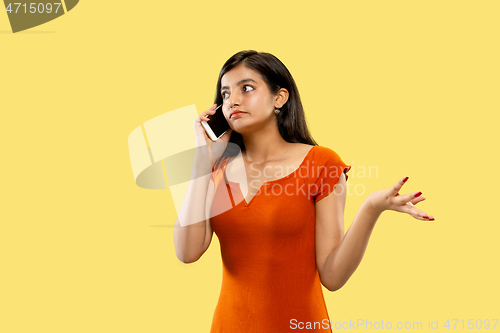 Image of Portrait of beautiful woman isolated on yellow studio background