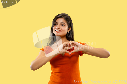 Image of Portrait of beautiful woman isolated on yellow studio background