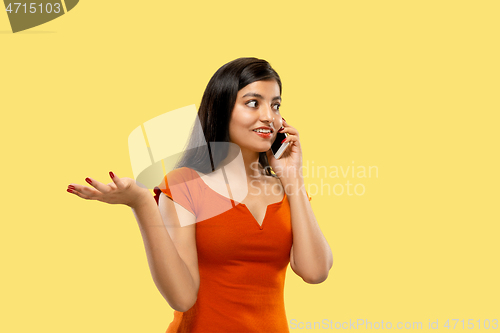 Image of Portrait of beautiful woman isolated on yellow studio background