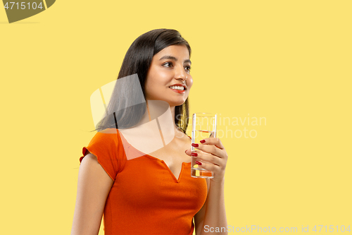 Image of Portrait of beautiful woman isolated on yellow studio background