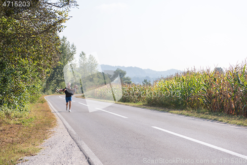 Image of happy couple jogging along a country road