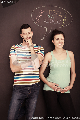 Image of pregnant couple writing on a black chalkboard