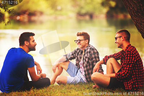 Image of men sitting on the bank of the river