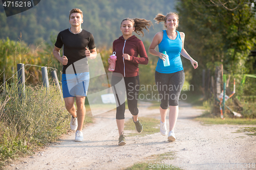 Image of young people jogging on country road