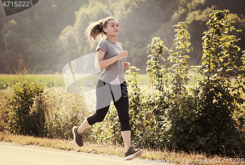 Image of woman jogging along a country road