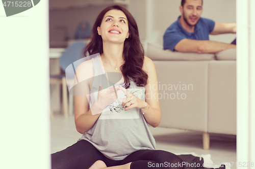 Image of pregnant couple checking a list of things for their unborn baby