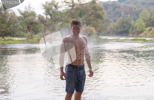 Image of man with a bare torso splashing water