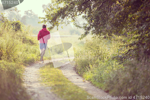 Image of man jogging along a country road