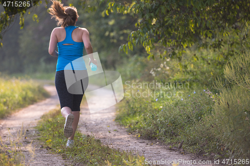 Image of woman jogging along a country road