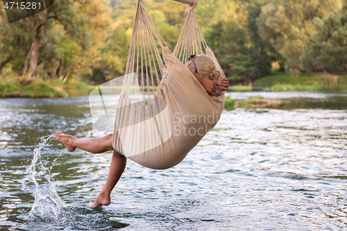 Image of blonde woman resting on hammock