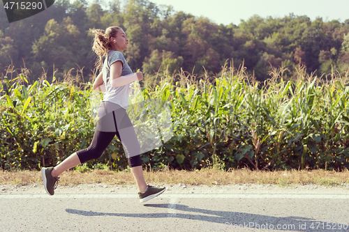 Image of woman jogging along a country road