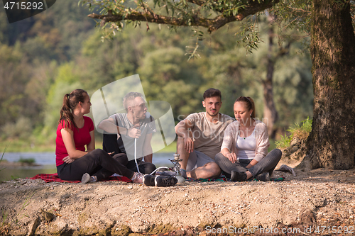 Image of friends smoking hookah on the river bank