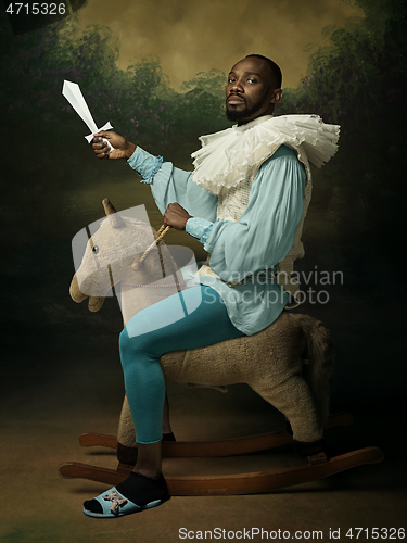 Image of Young man as a medieval knight on dark background