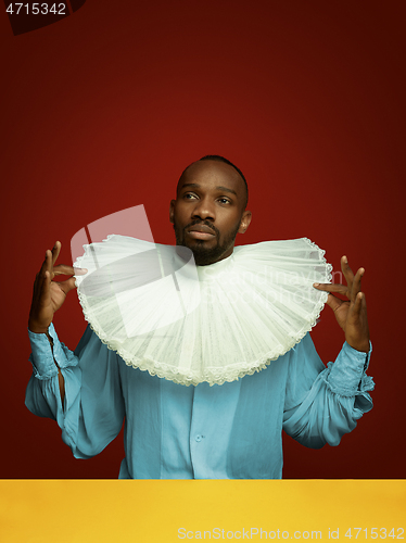 Image of Young man as a medieval grandee on red background