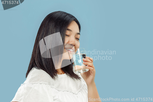 Image of Korean young woman\'s half-length portrait on blue background