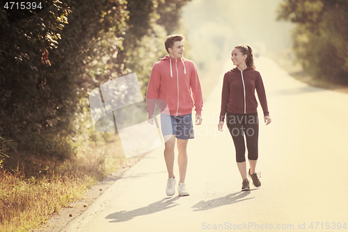 Image of young couple jogging along a country road