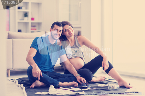 Image of pregnant couple checking a list of things for their unborn baby