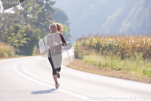 Image of woman jogging along a country road