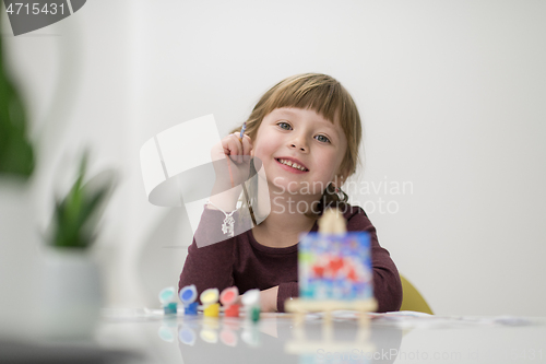 Image of little girl painting on canvas