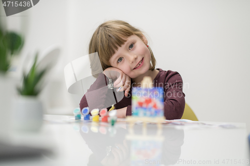 Image of little girl painting on canvas