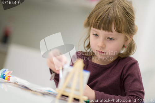 Image of little girl painting on canvas