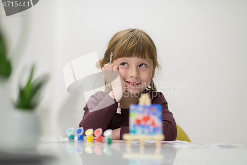 Image of little girl painting on canvas