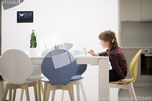 Image of little girl painting on canvas