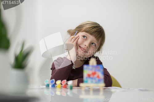 Image of little girl painting on canvas