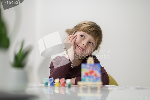 Image of little girl painting on canvas