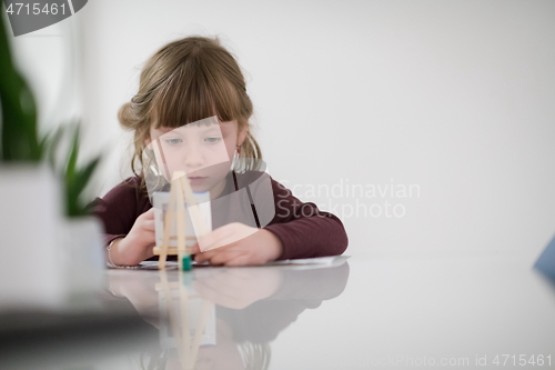 Image of little girl painting on canvas