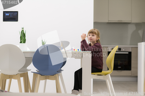 Image of little girl painting on canvas