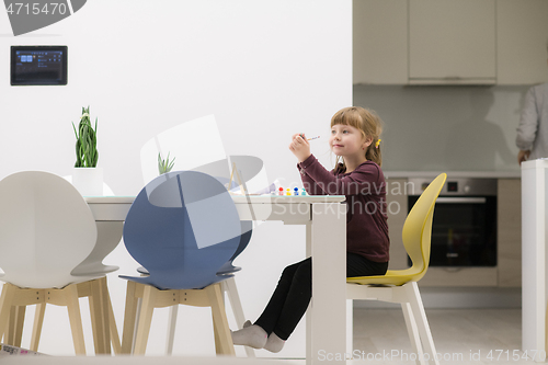 Image of little girl painting on canvas