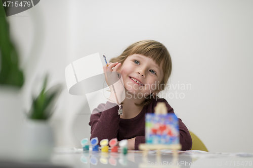 Image of little girl painting on canvas